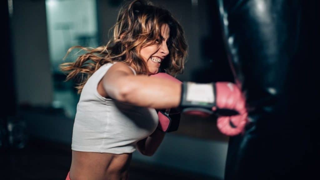 woman using strength for punching bag