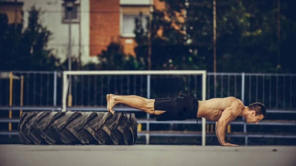 a body weight workout with truck tire for push ups.